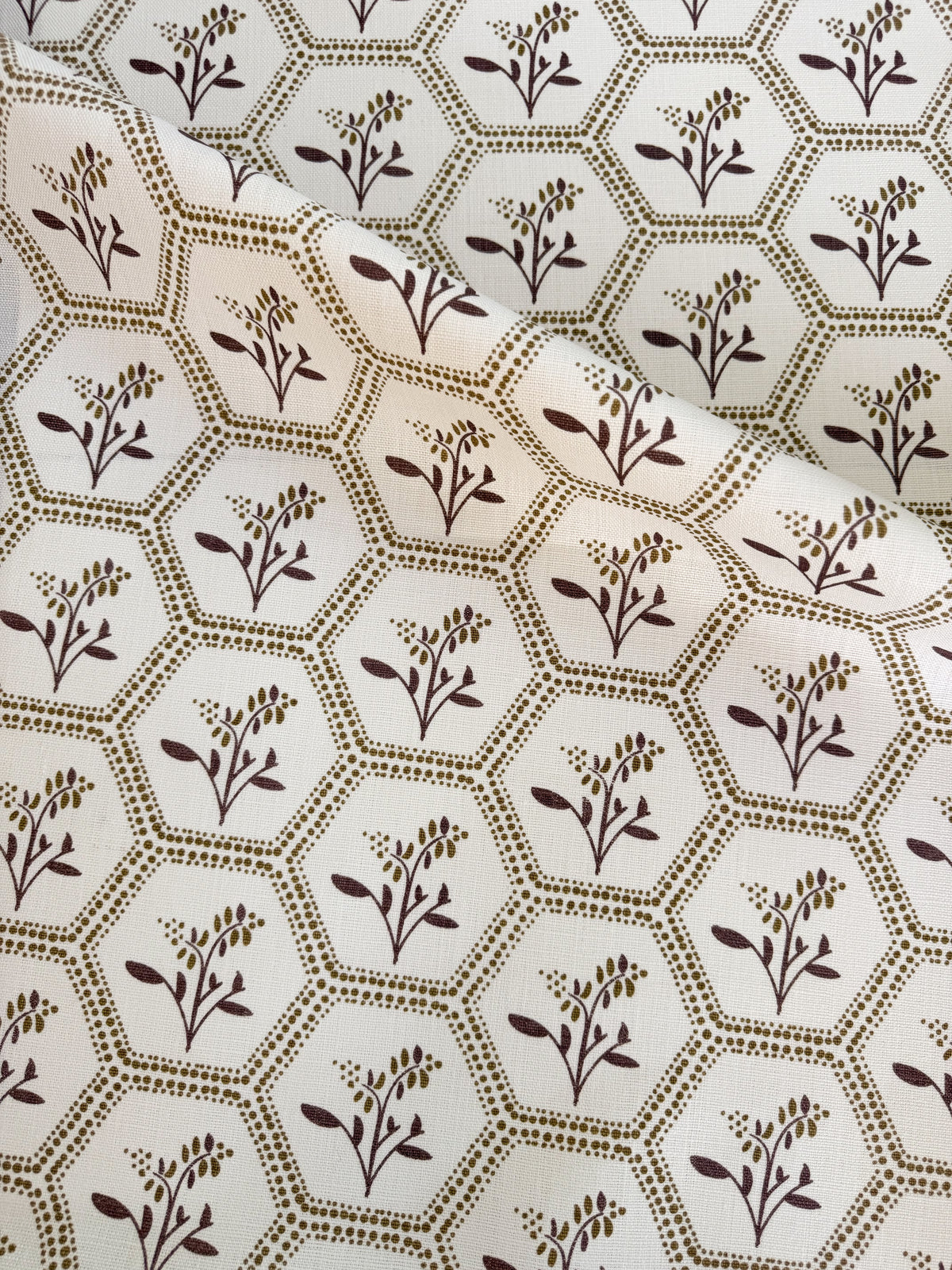 Greige Textiles Enid from Collection 12, a graceful decorative fabric pairing geometric honeycomb structure with delicate Astrantia blooms