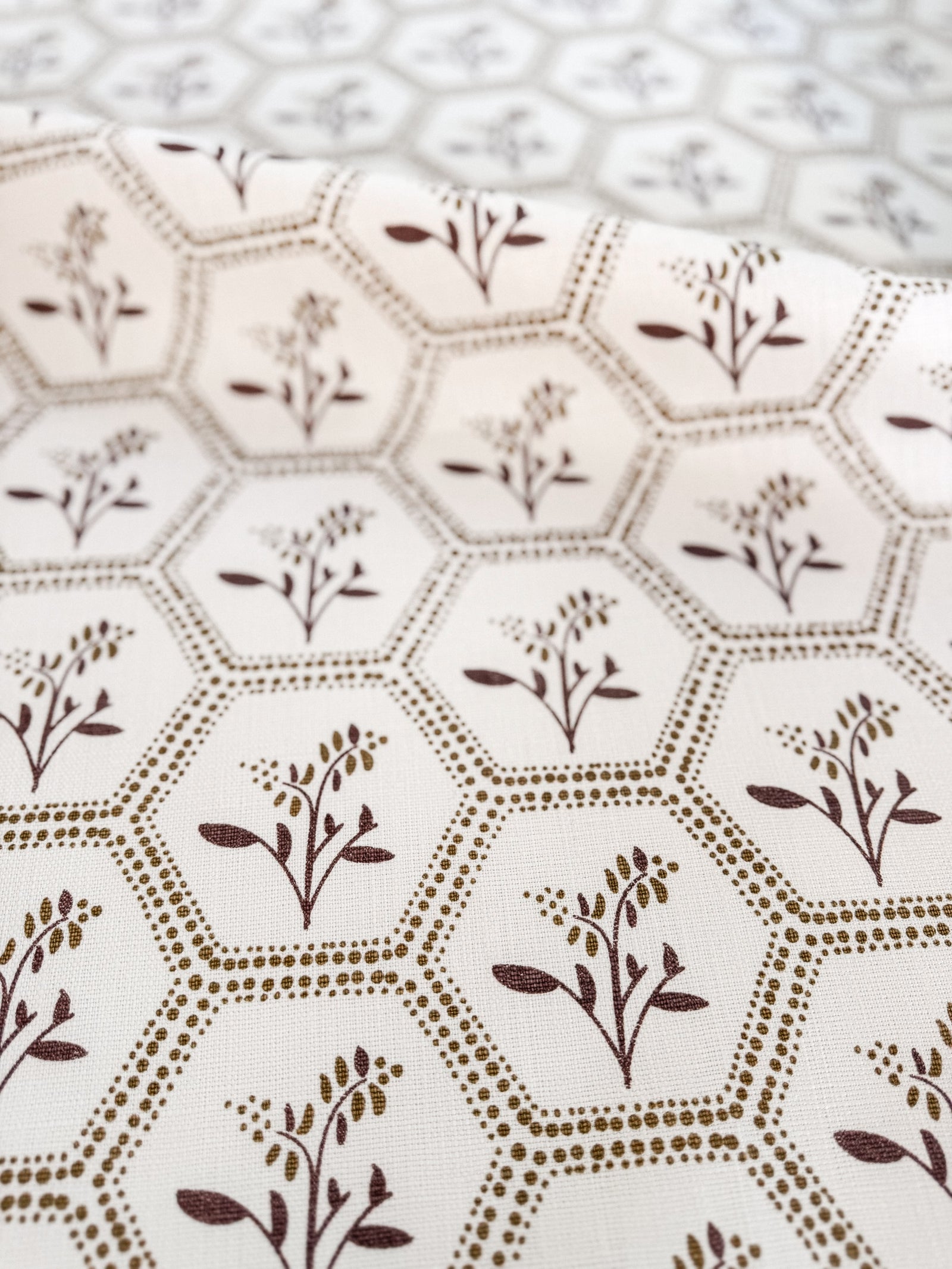 Greige Textiles Enid from Collection 12, a graceful decorative fabric pairing geometric honeycomb structure with delicate Astrantia blooms