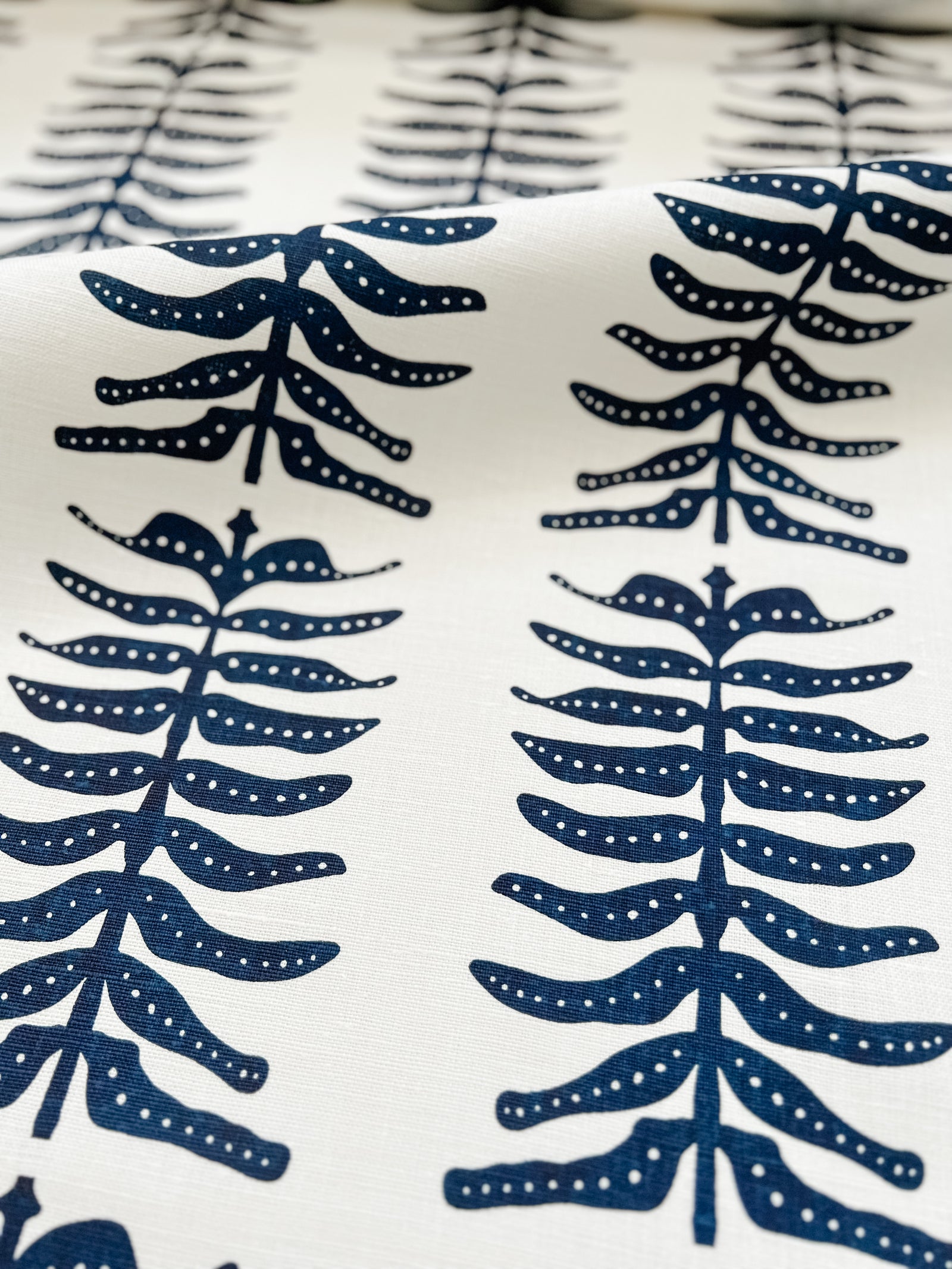 greige textiles Odette Fabric Indigo on Oyster. Elevate your home with Greige Textiles' lively collection of hand screen-printed linen fabrics and artisan wallpapers.