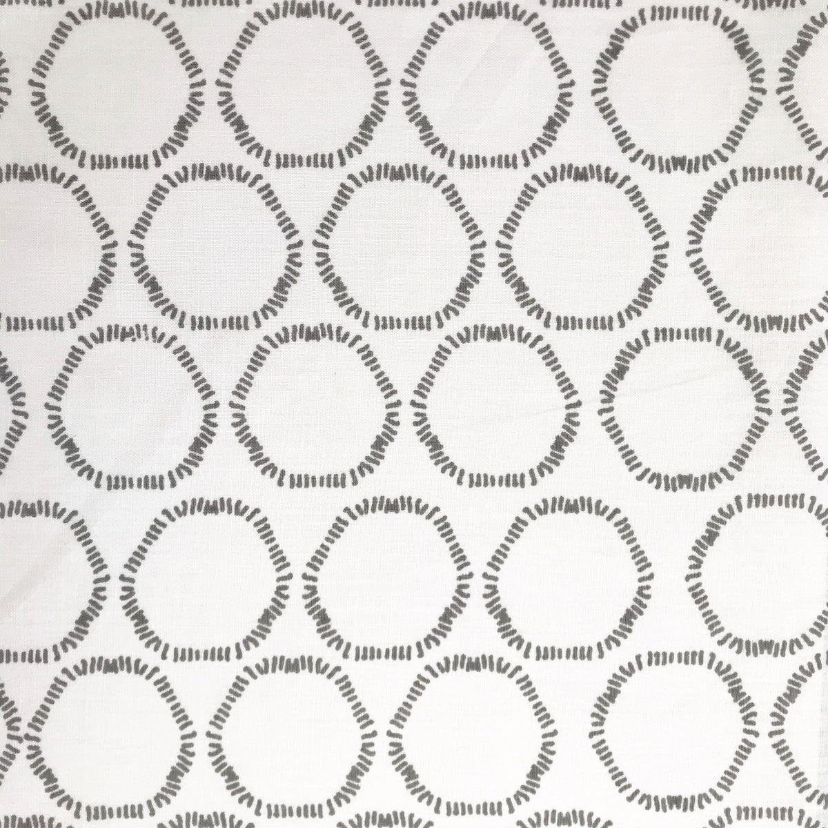 Cape pattern from Greige Textiles — organic, open circles hand printed on premium Belgian linen, suited for pillows, curtains, and light upholstery.
