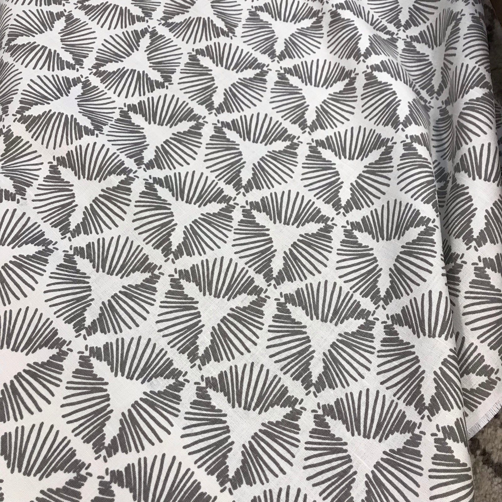Cie – where geometry meets excitement. A bold starburst shield pattern printed on luxurious Belgian linen, designed to bring theatrical flair and flow to interior spaces."