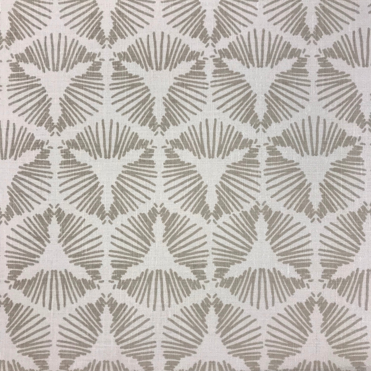 Cie by Greige Textiles channels bold movement and graphic drama in its radiant starburst shield pattern, hand printed on Belgian linen for statement-making design moments