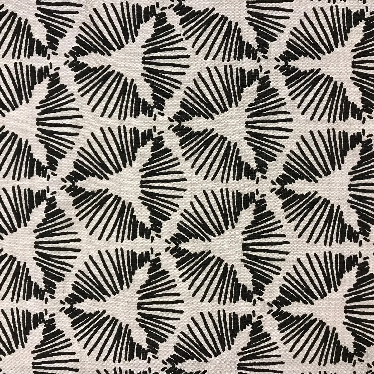 Cie by Greige Textiles — a dramatic starburst shield motif that brings graphic energy and sculptural movement to interiors. Hand printed on Belgian linen, it&#39;s a bold choice for drapery, statement cushions, or tailored upholstery.