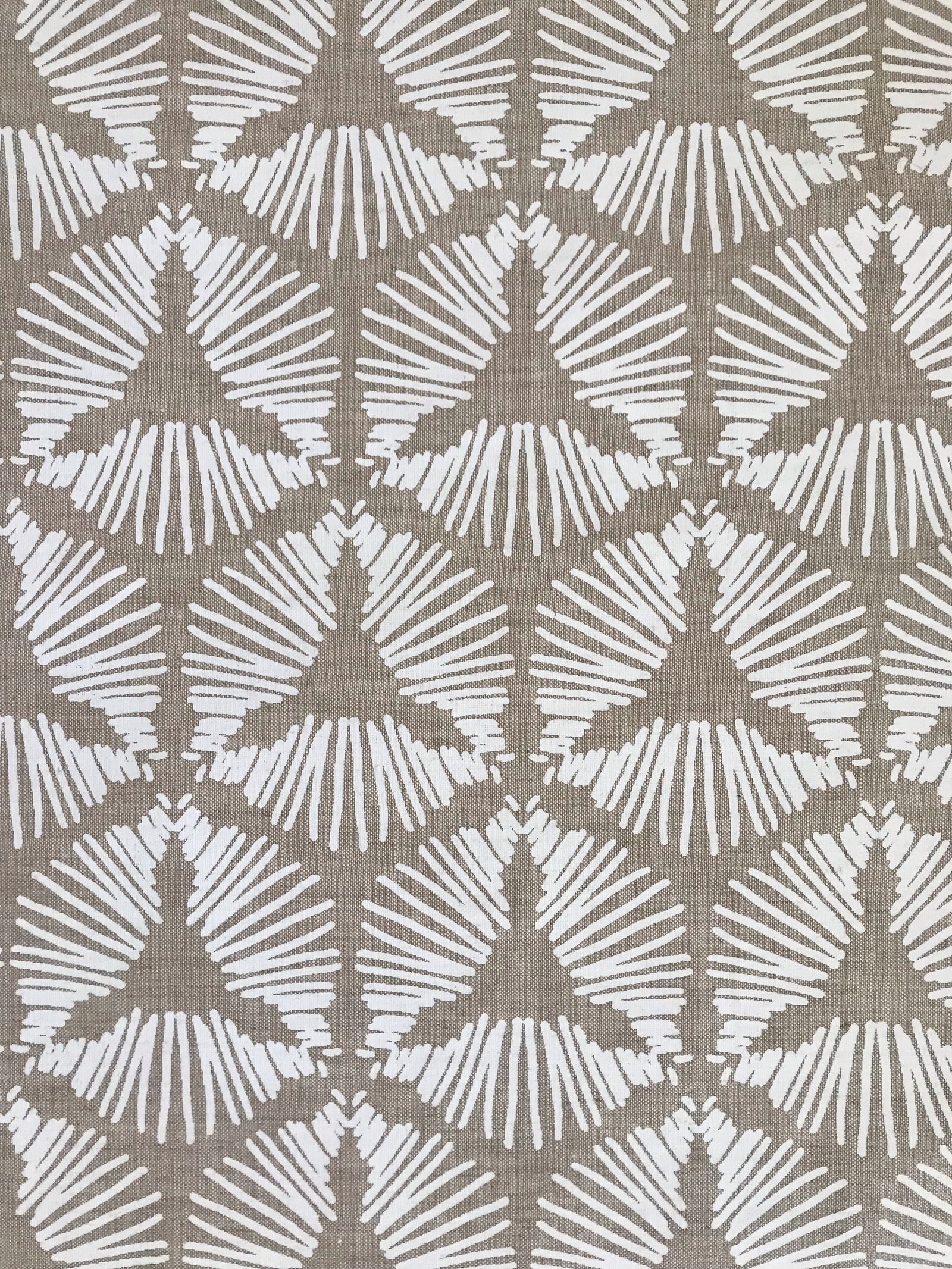 The Cie pattern radiates striking visual rhythm with its bold starburst shield design. A dynamic textile hand printed on Belgian linen, ideal for upholstery, cushions, and drapery in spaces that embrace graphic elegance.