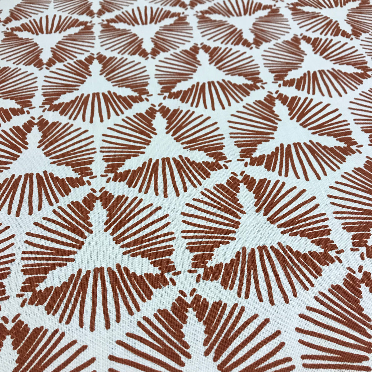greige textiles cie in burnt orange on oyster Hand screen printed in California on the finest Belgian linen, this design is a versatile choice for interiors that embrace texture, bold pattern, and thoughtful craftsmanship.