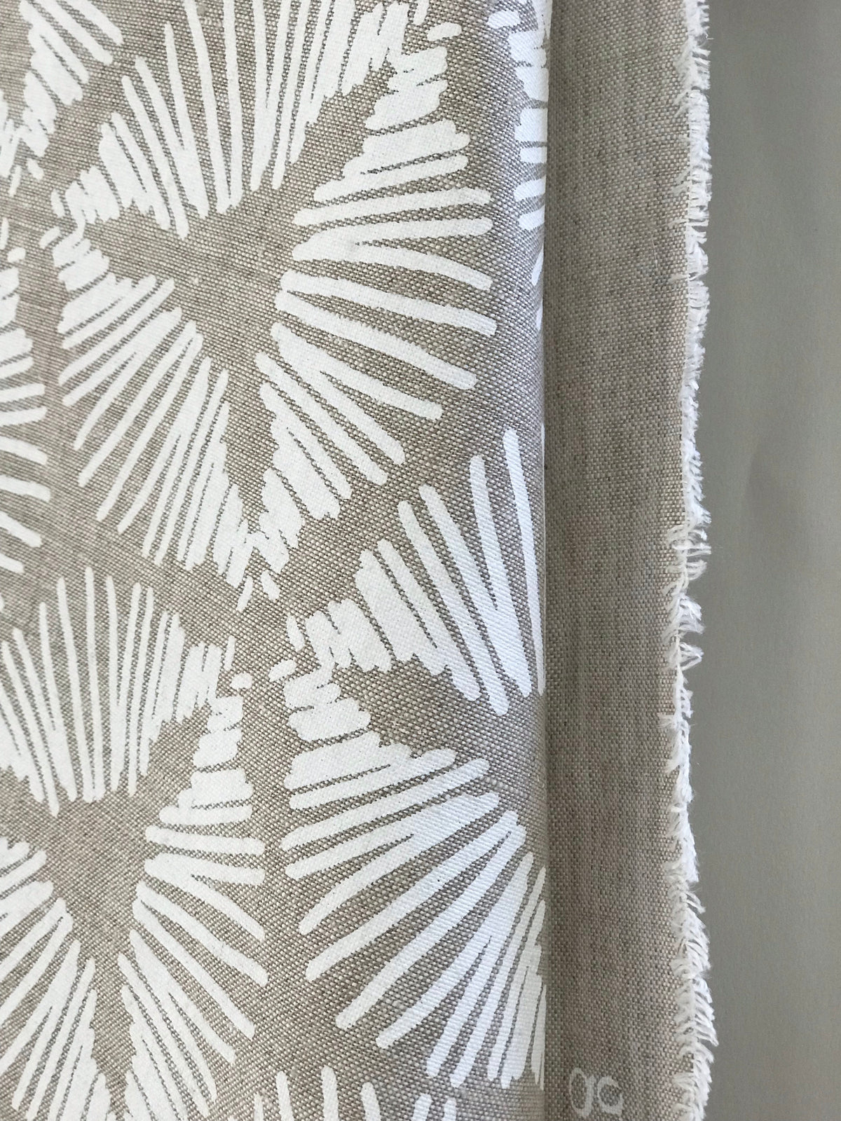 The Cie pattern radiates striking visual rhythm with its bold starburst shield design. A dynamic textile hand printed on Belgian linen, ideal for upholstery, cushions, and drapery in spaces that embrace graphic elegance.